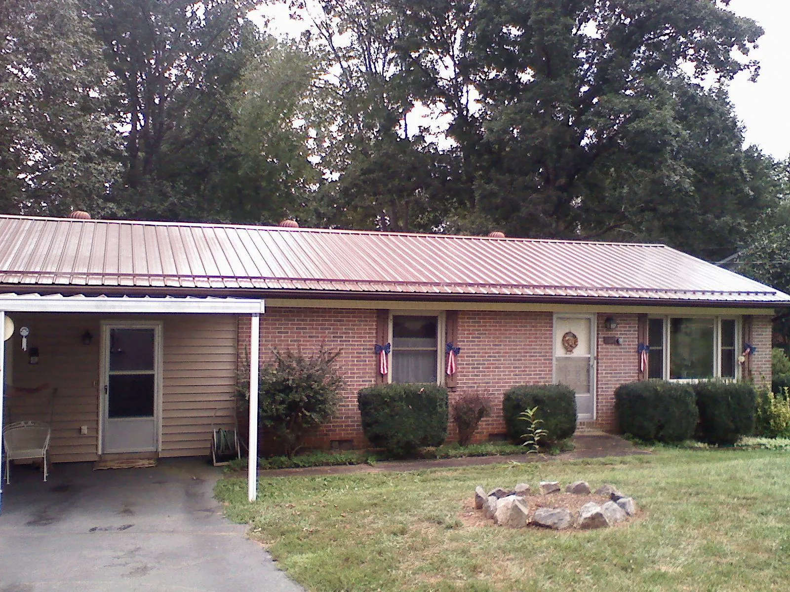 Bronze metal roof and carport on a brick ranch home — Roof Repair work by our crew in Cannonville