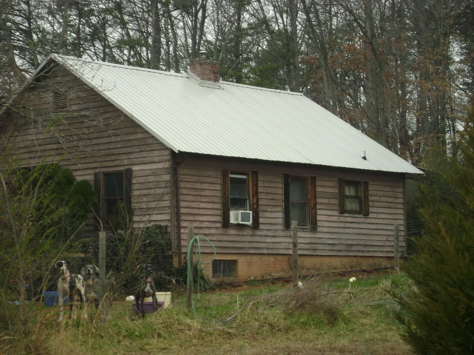 White metal roof on an old wood sided farmhouse, from a Metal Roof Installation job in Cannonville